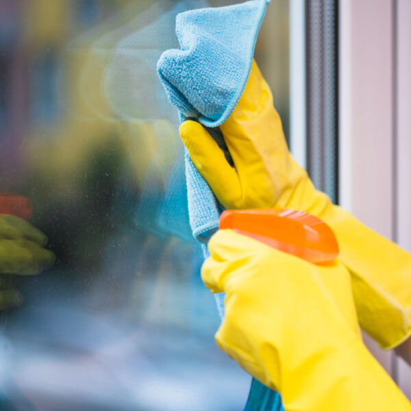 Limpiando una ventana con limpiavidrios Aldex.